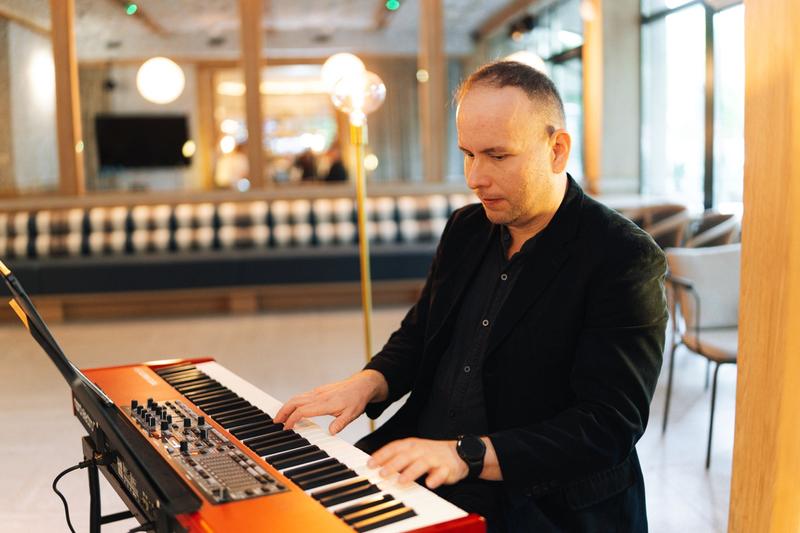 Fotografia eventowa z kolacji degustacyjnej w Szczecinie — muzyk grający na keyboardzie w luksusowym hotelu.