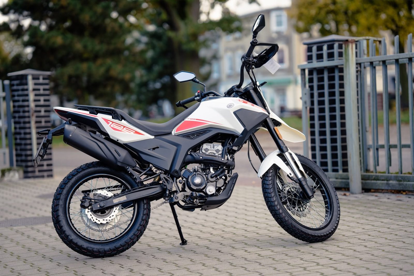 Biało-czerwony motocykl zaparkowany na chodniku