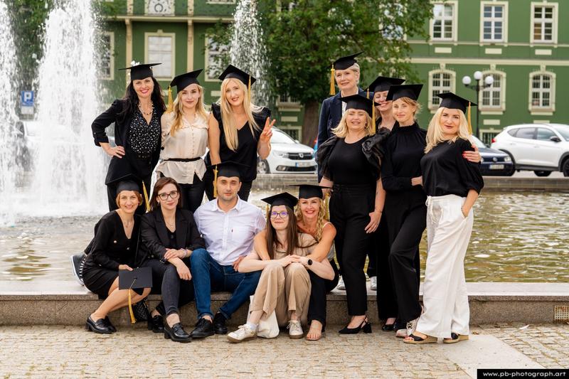 Reportaż z absolutorium w Szczecinie — grupa absolwentów z dyplomami w Parku Kasprowicza.