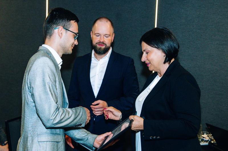Wręczenie certyfikatów w piwnicy hotelu Fokus, emocje uczestników na tle ciemnych ścian.