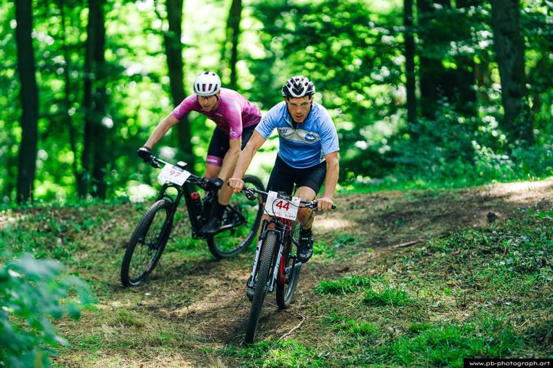 Fotografia sportowa z wyścigów MTB w Szczecinie — zawodnicy na trasie wśród zieleni.