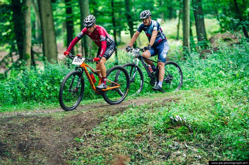 Fotografia sportowa z wyścigów MTB w Szczecinie — zawodnicy na trasie w lesie.