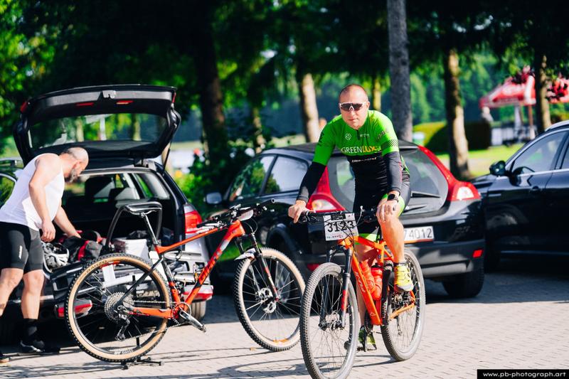 Fotografia sportowa z wyścigów MTB w Szczecinie — zawodnik przygotowujący się do startu obok roweru.