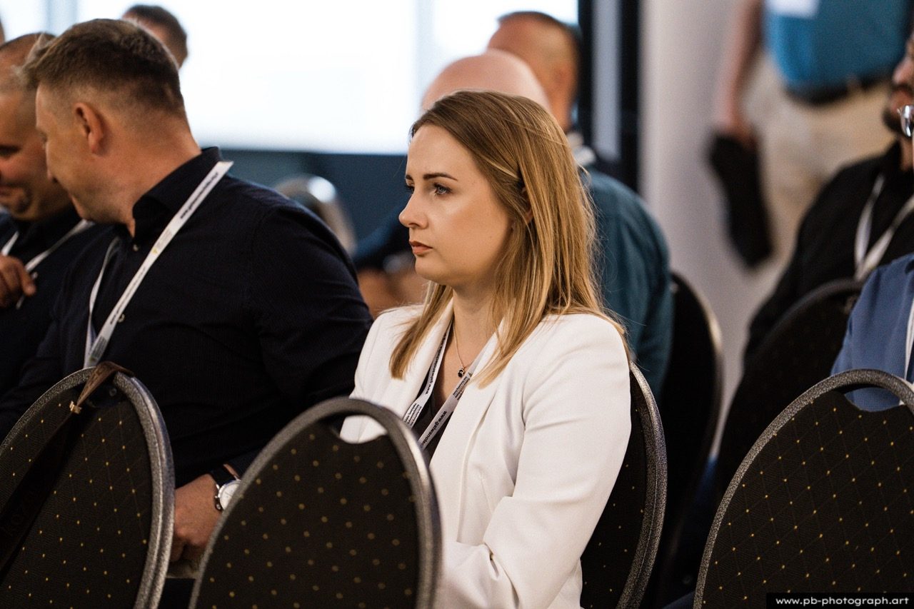 Kobieta w białej marynarce na konferencji.